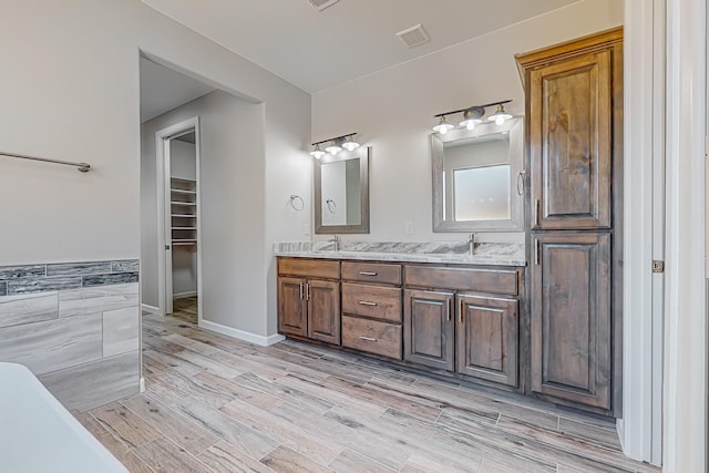 bathroom with hardwood / wood-style floors, vanity, and tile walls