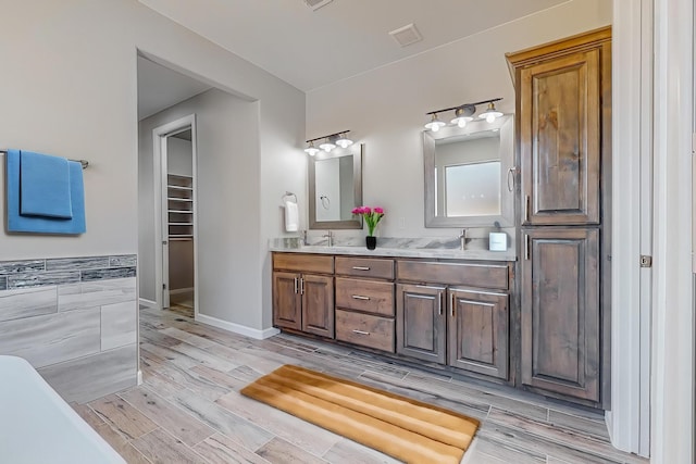 bathroom with hardwood / wood-style flooring, vanity, and tile walls