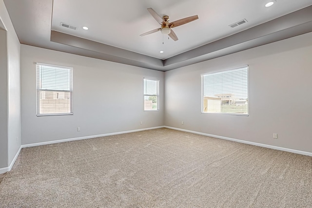 unfurnished room featuring carpet flooring, ceiling fan, and a tray ceiling