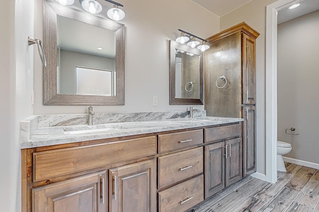 bathroom with wood-type flooring, vanity, and toilet