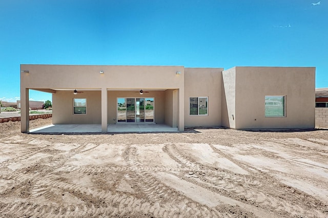 back of property with ceiling fan and a patio area