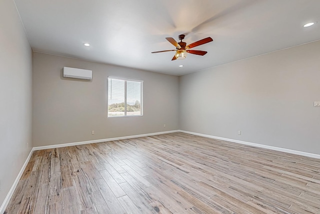 empty room with light hardwood / wood-style flooring, an AC wall unit, and ceiling fan