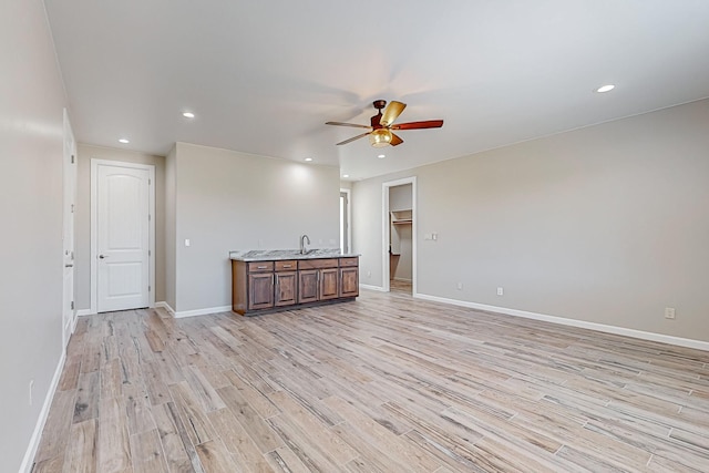 interior space with sink, ceiling fan, and light hardwood / wood-style flooring