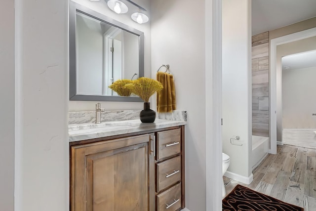 full bathroom with wood-type flooring, toilet, vanity, and bathtub / shower combination