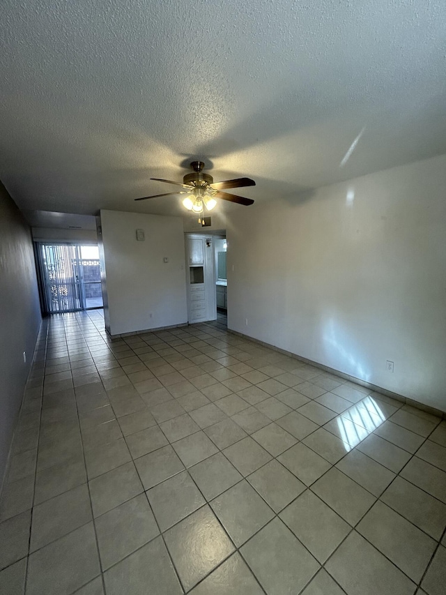 tiled spare room featuring ceiling fan