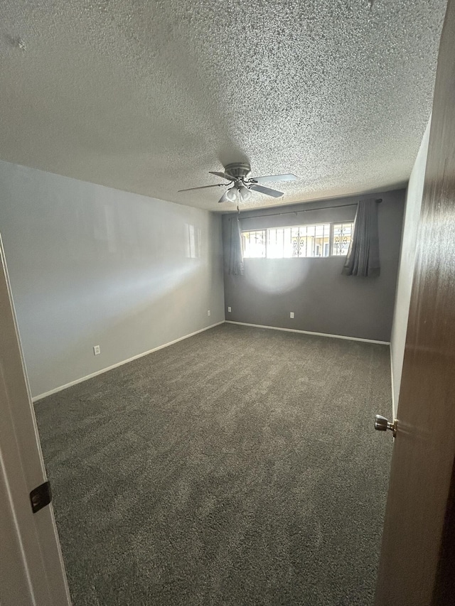 unfurnished room with dark colored carpet, ceiling fan, and a textured ceiling