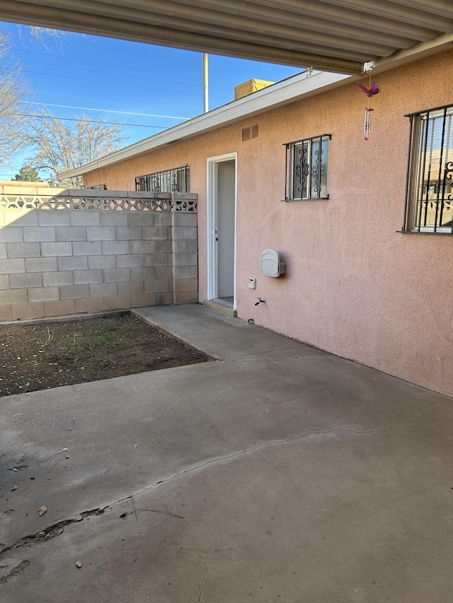 view of exterior entry with a patio area