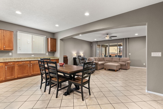 tiled dining room featuring a textured ceiling and ceiling fan