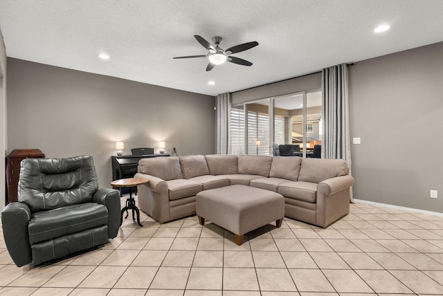 living room with a textured ceiling, light tile patterned floors, and ceiling fan