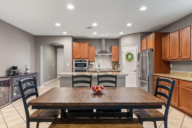 dining area featuring a textured ceiling, light tile patterned flooring, and wine cooler