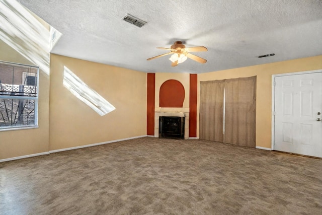 unfurnished living room featuring carpet flooring, a textured ceiling, and ceiling fan