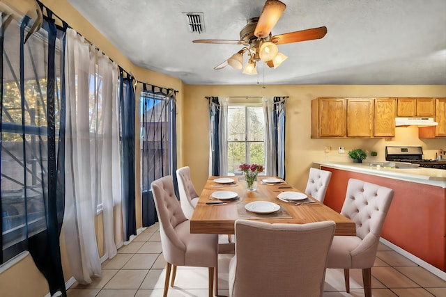 tiled dining space featuring ceiling fan