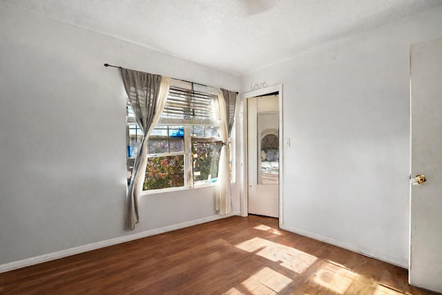 spare room featuring hardwood / wood-style floors and a textured ceiling