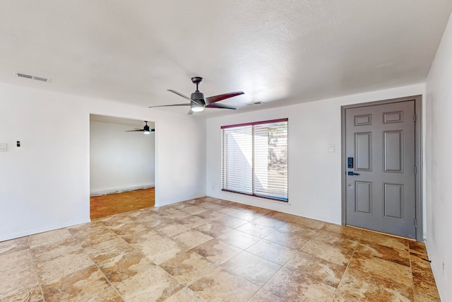 entryway featuring ceiling fan and a textured ceiling