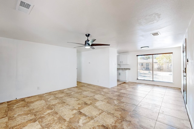 unfurnished living room with ceiling fan