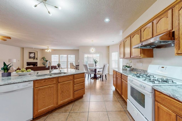 kitchen with pendant lighting, white appliances, ventilation hood, sink, and light tile patterned flooring