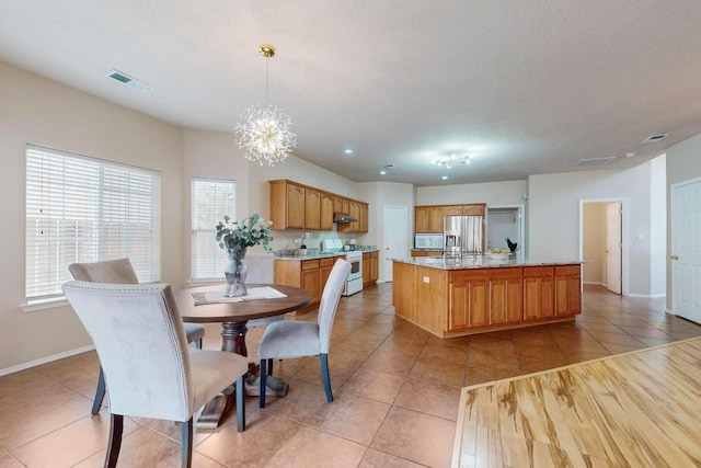 dining space with a notable chandelier and light tile patterned flooring