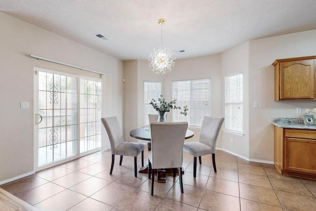 dining room featuring a notable chandelier, plenty of natural light, and light tile patterned floors