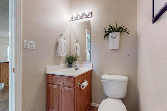 bathroom featuring tile patterned floors, vanity, and toilet