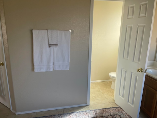 bathroom with toilet, vanity, and tile patterned floors