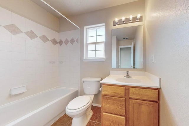 full bathroom featuring tiled shower / bath, tile patterned flooring, vanity, and toilet