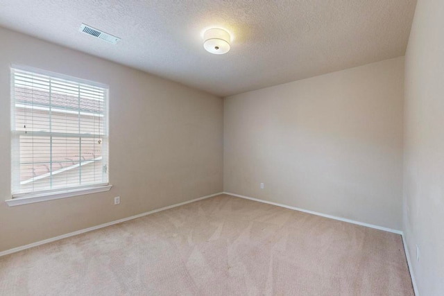 carpeted spare room with a textured ceiling