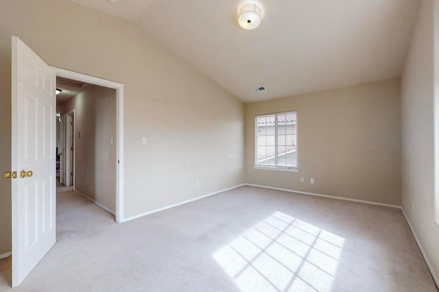 empty room featuring light carpet and lofted ceiling