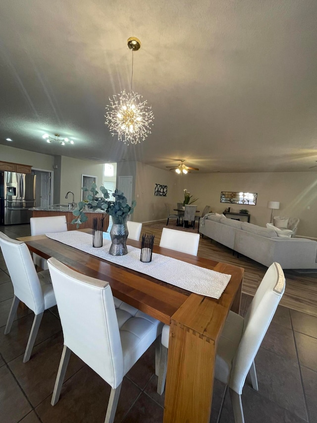 tiled dining space with a textured ceiling and an inviting chandelier