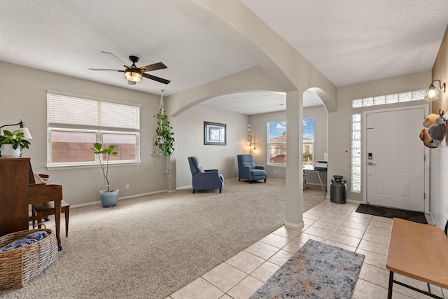 carpeted entrance foyer with ceiling fan and a textured ceiling