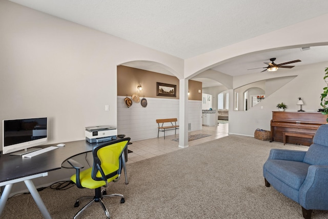 carpeted home office with ceiling fan and a textured ceiling