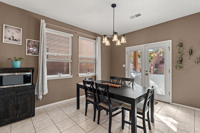 dining space featuring an inviting chandelier, light tile patterned floors, and french doors