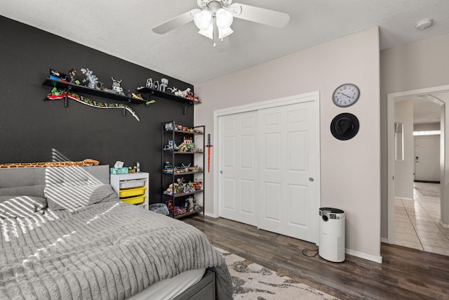 bedroom with ceiling fan, dark hardwood / wood-style flooring, and a closet