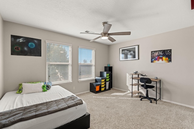 carpeted bedroom with ceiling fan and a textured ceiling