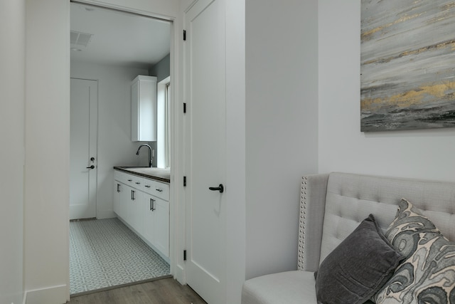 hallway with light hardwood / wood-style floors and sink