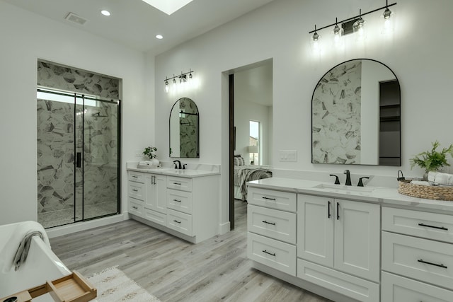 bathroom featuring an enclosed shower, vanity, hardwood / wood-style flooring, and a wealth of natural light