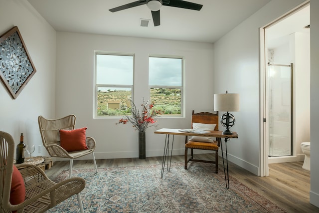 sitting room with ceiling fan and wood-type flooring