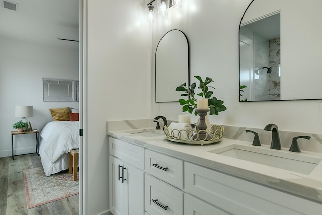 bathroom featuring hardwood / wood-style floors, vanity, and a shower