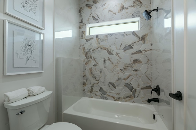 bathroom with toilet and tiled shower / bath