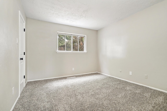 carpeted spare room with a textured ceiling