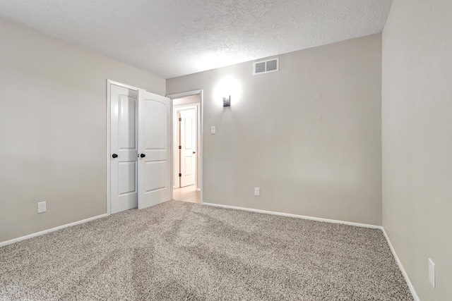 unfurnished room featuring a textured ceiling and carpet floors