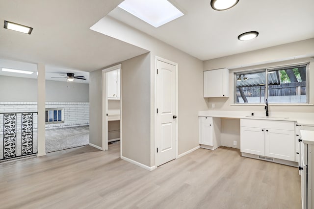 kitchen featuring light hardwood / wood-style floors, white cabinetry, and sink