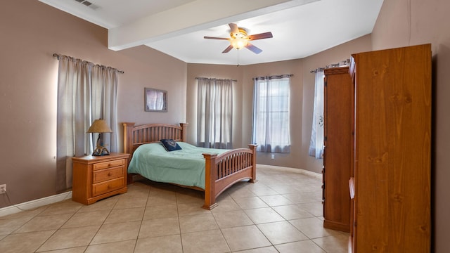 tiled bedroom with ceiling fan and beam ceiling