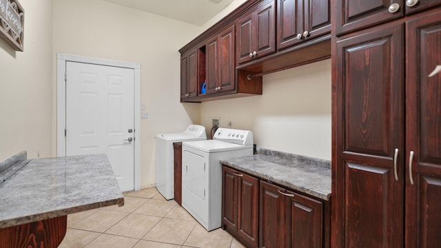 clothes washing area featuring cabinets, washer and dryer, and light tile patterned floors