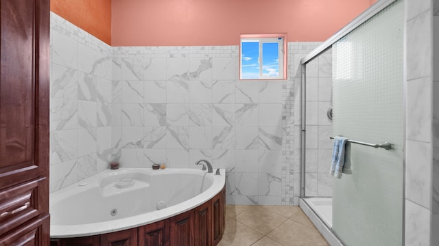 bathroom with tile walls, separate shower and tub, and tile patterned floors