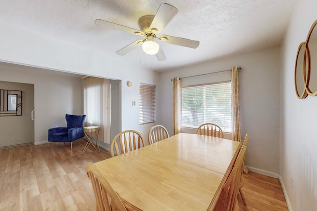 dining area with a textured ceiling, light hardwood / wood-style flooring, and ceiling fan