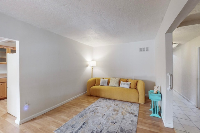 living room featuring light hardwood / wood-style floors and a textured ceiling