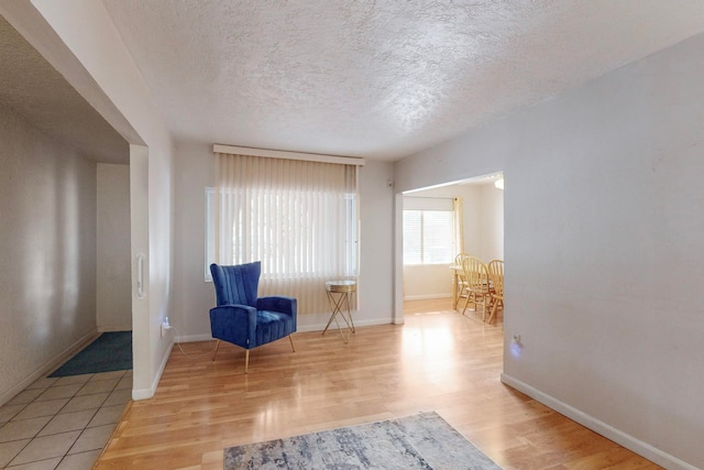 living area with wood-type flooring and a textured ceiling