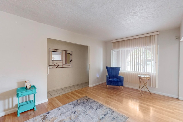 sitting room with hardwood / wood-style floors and a textured ceiling