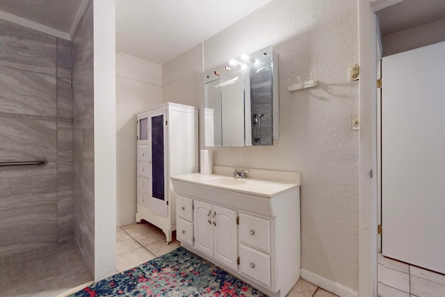 bathroom with tiled shower, tile patterned flooring, and vanity