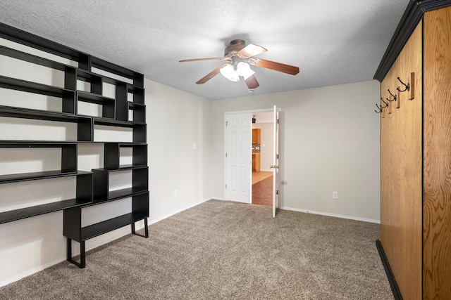 unfurnished bedroom with dark colored carpet, a textured ceiling, and ceiling fan